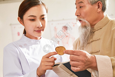 老中医给年轻医生讲解中药成分图片