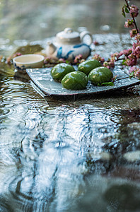 雨中盘子里的青团和茶具图片