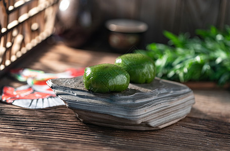 东方食物状态美食古典式屋内木桌上岩石盘里的青团背景图片