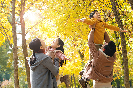 在公园看见落叶幸福家庭在户外玩耍背景