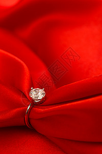 节日绸缎祝福红丝绸和钻石戒指背景图片