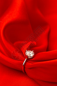 垂直构图情人节华丽的红丝绸和钻石戒指背景图片