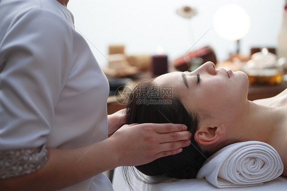 太阳穴按摩年轻女人在室内做SPA图片