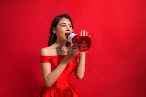 裙子色彩鲜艳红色背景青年女人拿着话筒图片