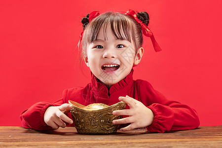 儿童节元素纯洁发髻可爱的小女孩拿着金元宝过新年背景