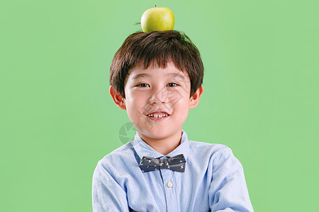 小男孩头上顶着一个苹果图片