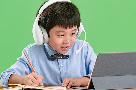 铅笔绿色背景东方人小学生使用平板电脑在线学习图片