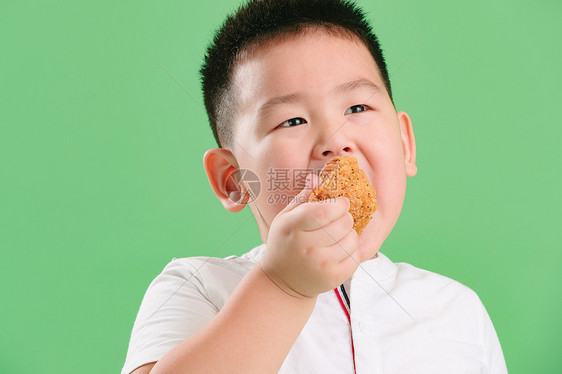 快乐油炸食品饥饿的可爱的小男孩吃炸鸡图片