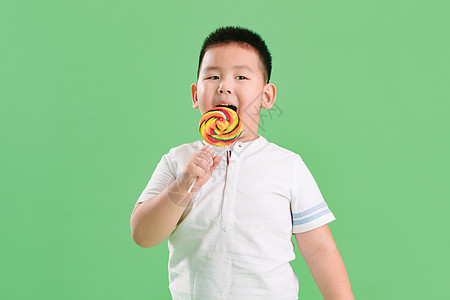 清新不健康食物微笑可爱的小男孩拿着棒棒糖高清图片