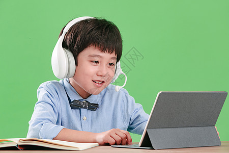 可爱的做作业活力小学生使用平板电脑在线学习背景图片