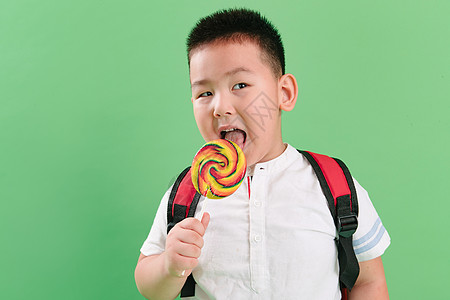 休闲装食品纯净可爱的小男孩拿着棒棒糖高清图片