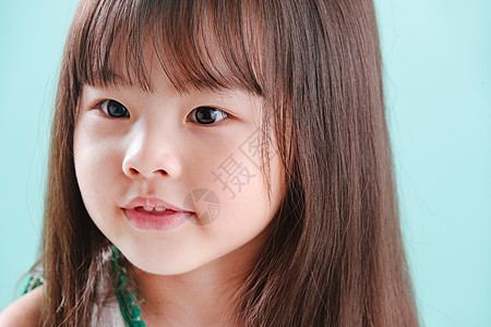 东亚蓝色背景亚洲小女孩的可爱表情图片