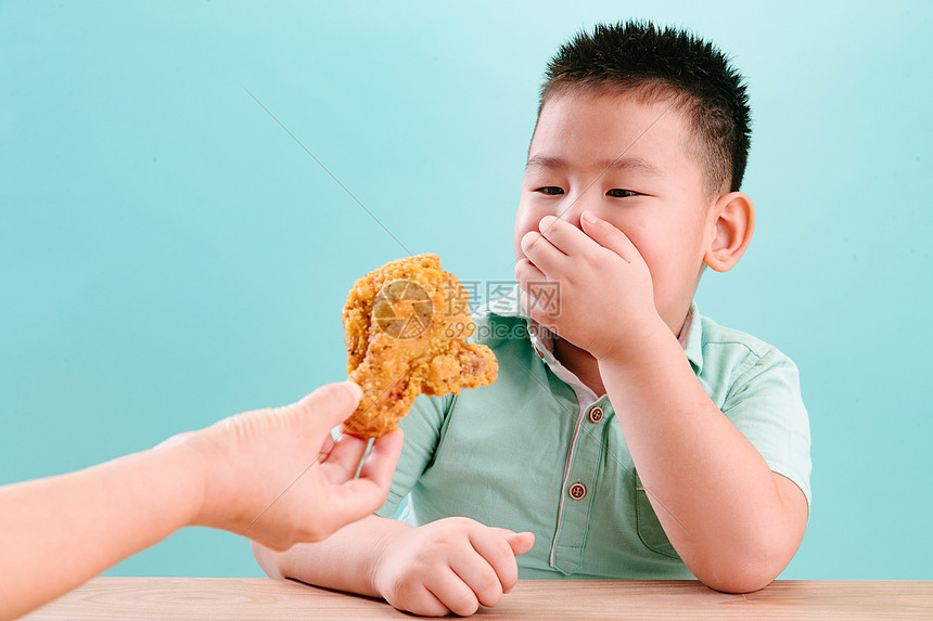 可爱的小男孩看着炸鸡图片