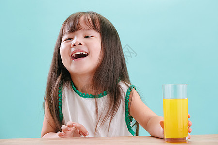 玻璃杯户内学龄前儿童可爱的小女孩喝饮料图片