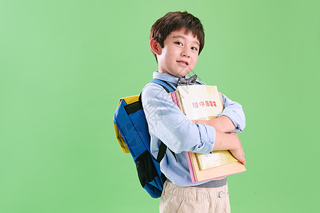 东方人绿色背景彩色图片背书包的快乐小学生背景图片