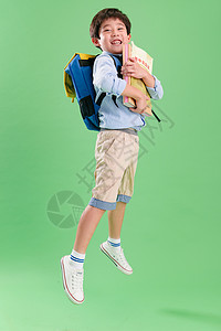 童年影棚拍摄休闲装背书包的快乐小学生图片