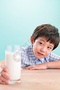 亚洲儿童豆浆小男孩看着一杯牛奶图片
