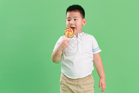 关爱诱惑偏好可爱的小男孩拿着棒棒糖图片