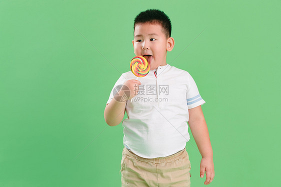 关爱诱惑偏好可爱的小男孩拿着棒棒糖图片