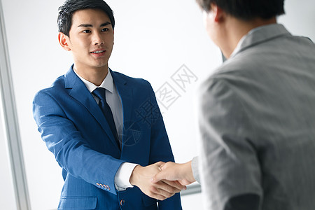 东亚表现积极影棚拍摄两个商务男人握手图片