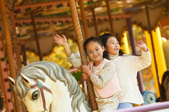两个小女孩在玩旋转木马图片