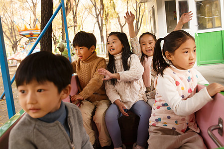 游乐场的孩子男孩女孩坐在游乐场玩耍背景