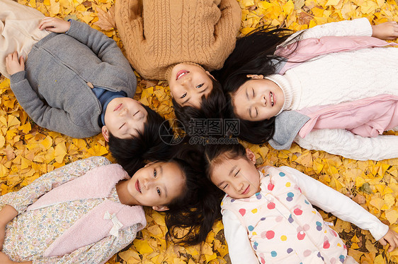秋天树林中男孩女孩躺在地上图片