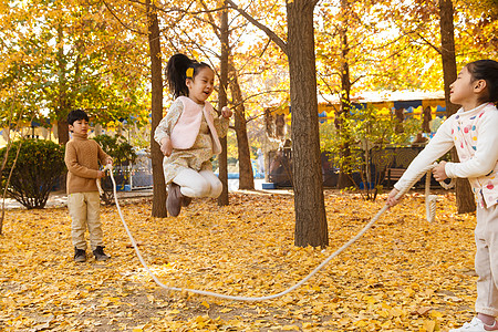 小学生跳绳秋天树林中周末活动男孩女孩在户外玩耍背景