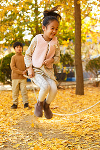 小学生跳绳男孩女孩在户外玩耍背景