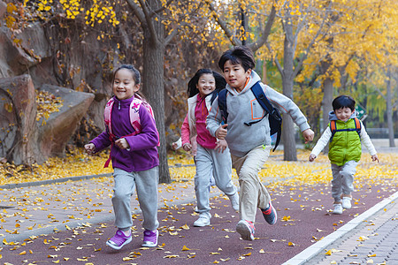 北京秋天欢乐的小学生在户外奔跑背景