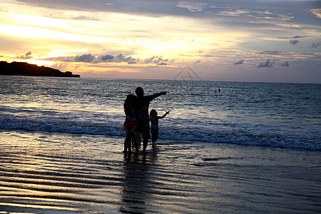 自然美非都市风光度假巴厘岛海滩上的家庭剪影图片