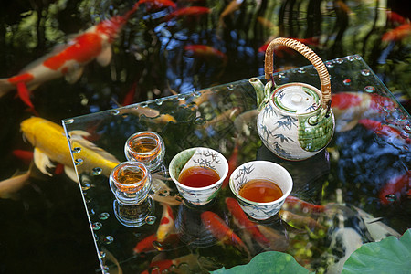锦鲤池塘边的茶具图片