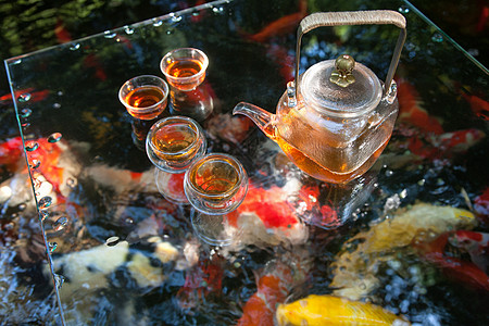 夏天池塘里的金鱼和水上的茶杯茶叶图片