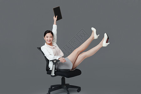 抬着腿坐在椅子女白领图片
