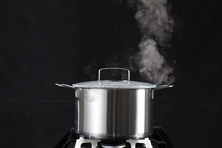 静物炊具黑色背景燃气灶和炖锅图片