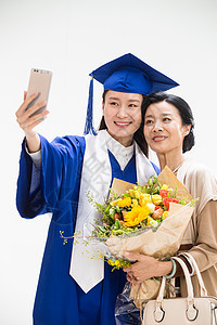 大学毕业庆祝的母女用手机拍照图片