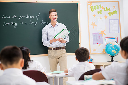 白种人关爱东方人教师和小学生在教室里图片