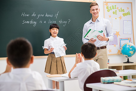 教育业职位学习乐趣教师和小学生在教室里背景图片