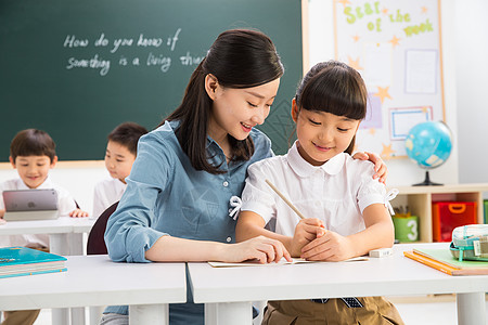 智慧生活成年人黑板课桌老师和小学生们在教室里背景