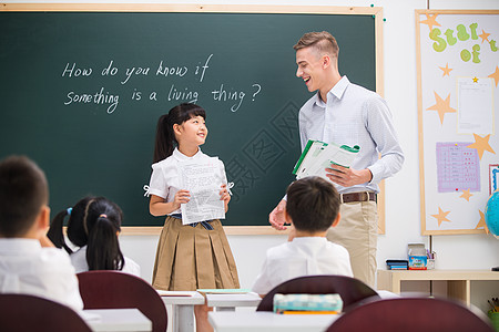 乐趣学龄儿童摄影教师和小学生在教室里图片