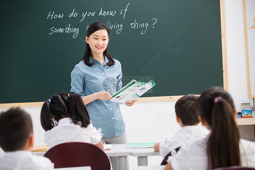 男孩学校关爱老师和小学生们在教室里