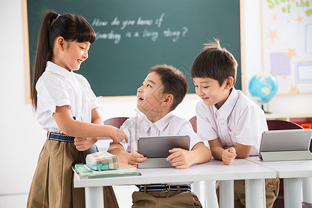 幸福天真小学生在使用平板电脑图片