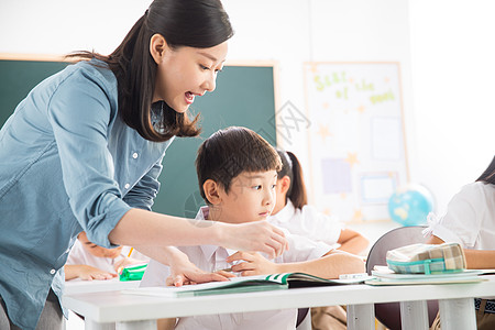 纯洁男孩女人老师和小学生们在教室里高清图片