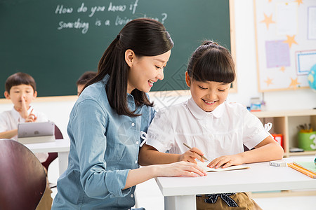 儿童看手机摄影成年人写字老师和小学生们在教室里背景