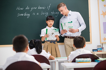 国际儿童日东亚指导教师现代教师和小学生在教室里背景