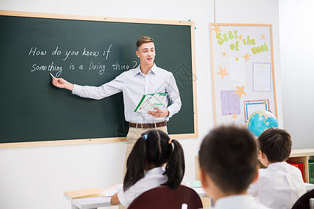 人女孩课桌教师和小学生在教室里图片