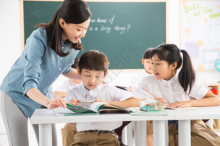 东亚学龄儿童责任老师和小学生们在教室里图片