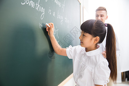 成年人相伴女孩老师在指导小学生学习图片