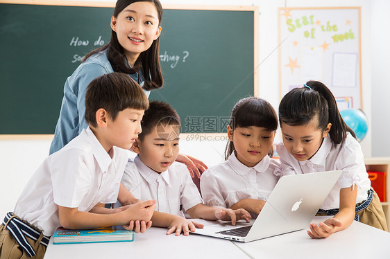 活力东亚在线教育教师和小学生在教室里使用电脑图片