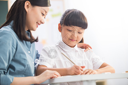 幸福亚洲人关爱老师在指导小学女生学习背景图片